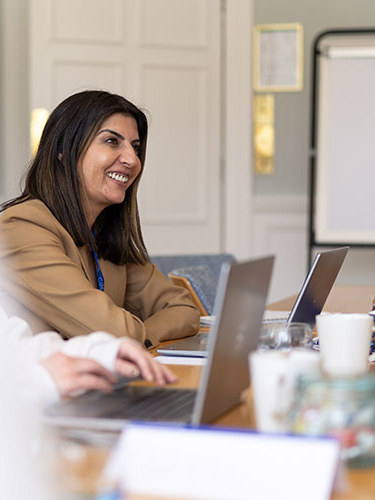 Woman smiling in a meeting room with a flip chart behind her
