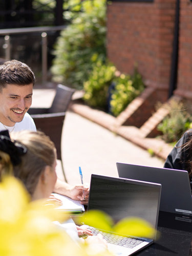 Group of young marketers having a meeting outside in the sun